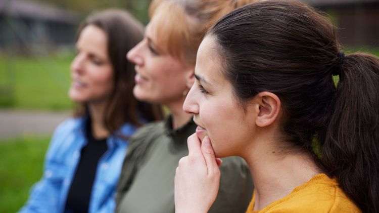 Drei Frauen schauen in die gleiche Richtung. 